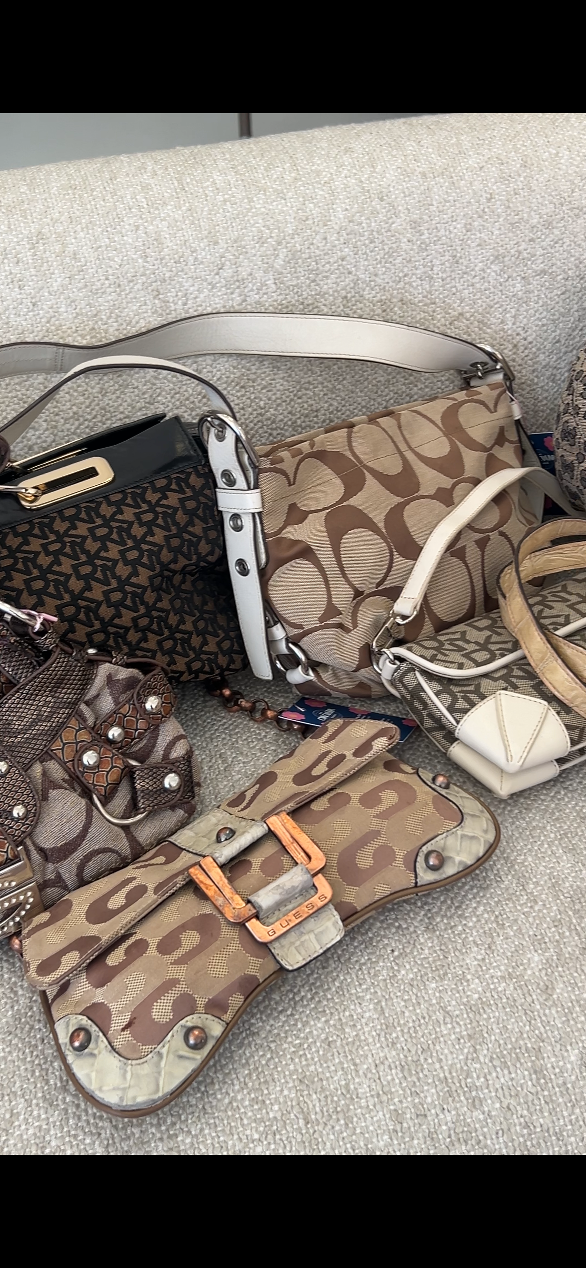 Collection of Coach handbags on a gray surface