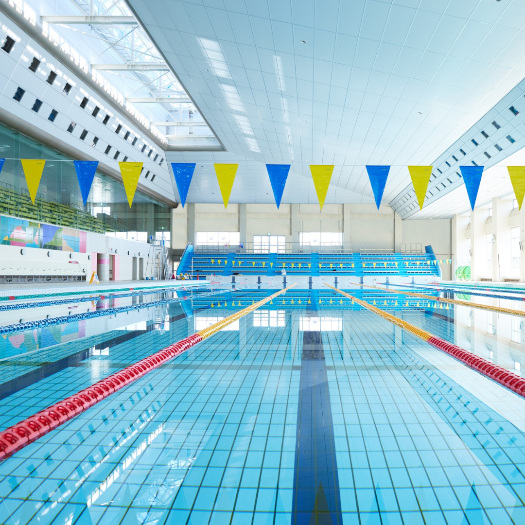 Indoor swimming pool with blue and yellow flags and red pool lanes.